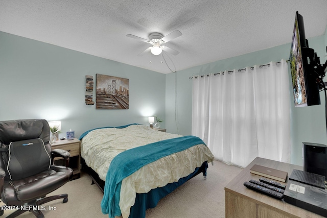 carpeted bedroom with ceiling fan and a textured ceiling