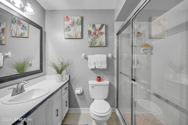 bathroom with vanity, tile patterned floors, toilet, a textured ceiling, and an enclosed shower