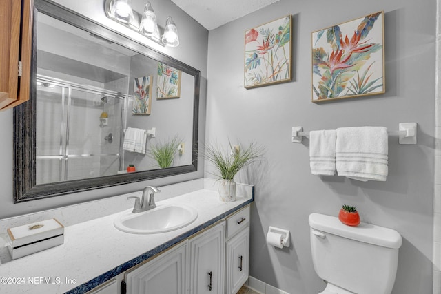 bathroom with vanity, toilet, and a shower with shower door