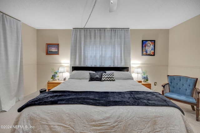 bedroom featuring ceiling fan, carpet floors, and a textured ceiling