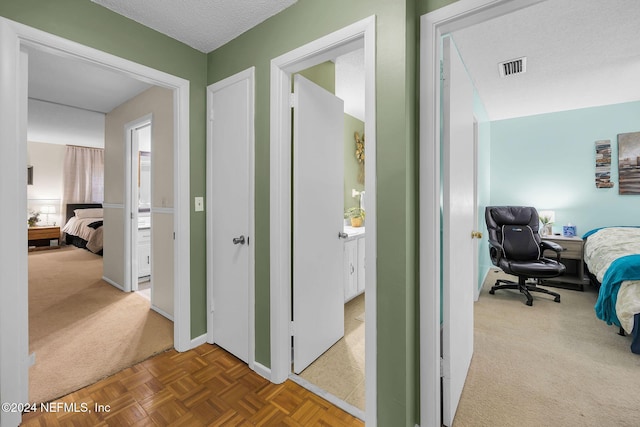 hall with carpet flooring and a textured ceiling