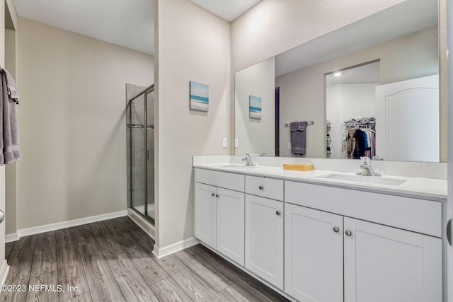 bathroom featuring hardwood / wood-style floors, vanity, and walk in shower