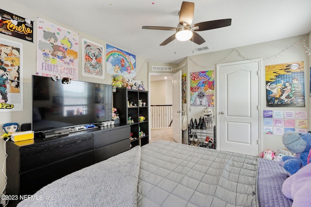 carpeted bedroom with ceiling fan and a textured ceiling