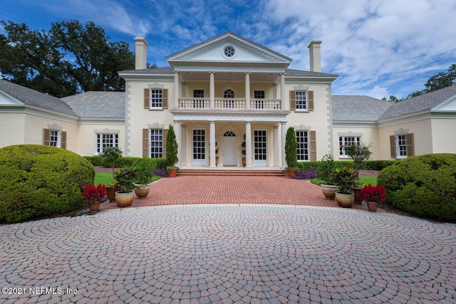 greek revival inspired property featuring a balcony