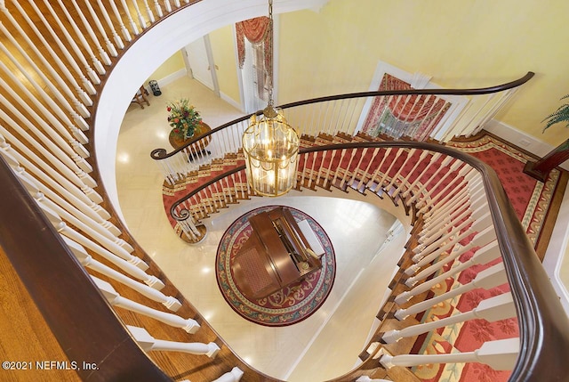 staircase with a notable chandelier