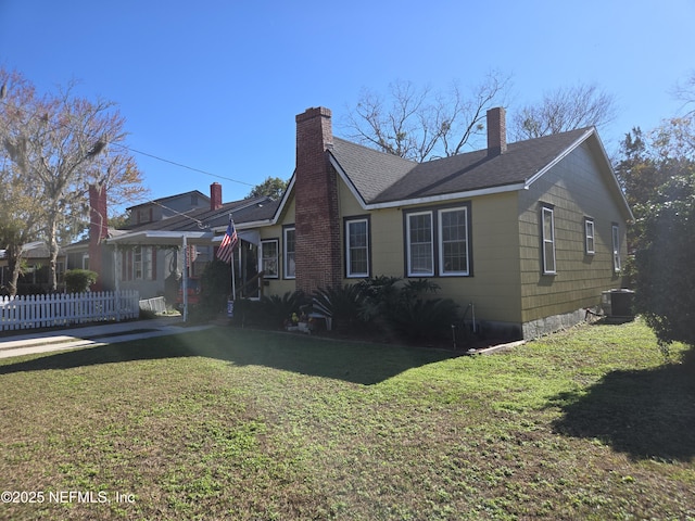 view of side of property featuring cooling unit and a lawn