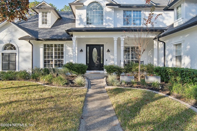 view of exterior entry with a yard