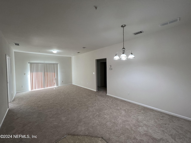 unfurnished room featuring carpet and a notable chandelier