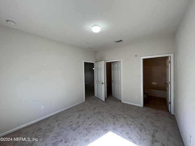 unfurnished bedroom with light colored carpet and ensuite bath