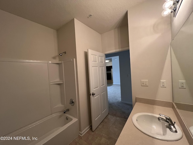 bathroom featuring vanity, a textured ceiling, and shower / washtub combination