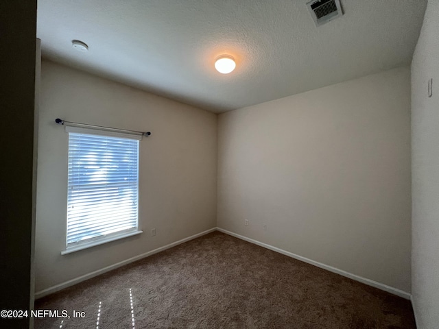 unfurnished room featuring carpet floors and a textured ceiling