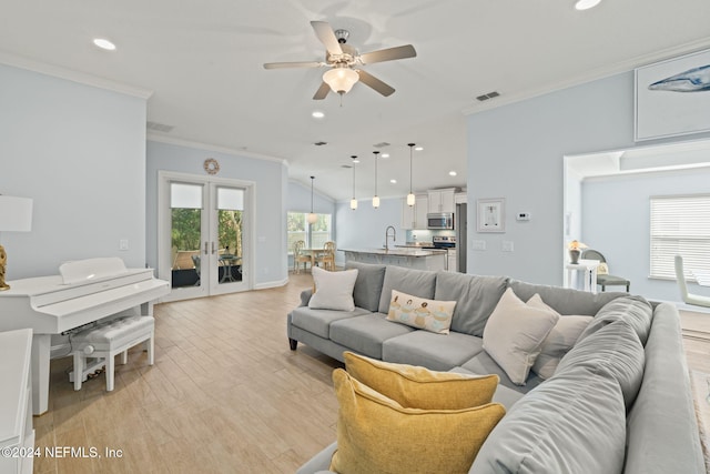 living room featuring french doors, vaulted ceiling, ceiling fan, ornamental molding, and light hardwood / wood-style floors