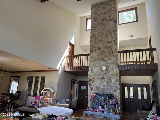 living room with a fireplace, a towering ceiling, and wood-type flooring