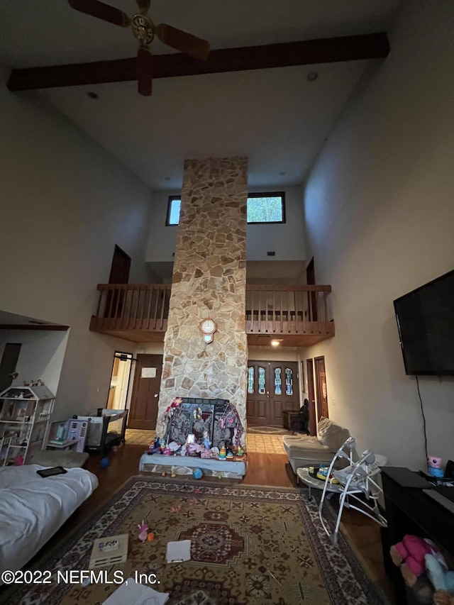 living room with beamed ceiling, hardwood / wood-style flooring, high vaulted ceiling, and ceiling fan