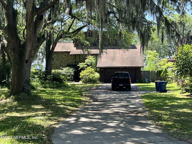 view of front of property featuring a garage and a front lawn