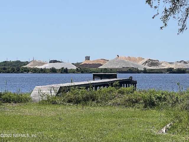 property view of water with a mountain view and a dock