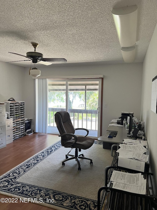 office space featuring hardwood / wood-style floors, ceiling fan, and a textured ceiling