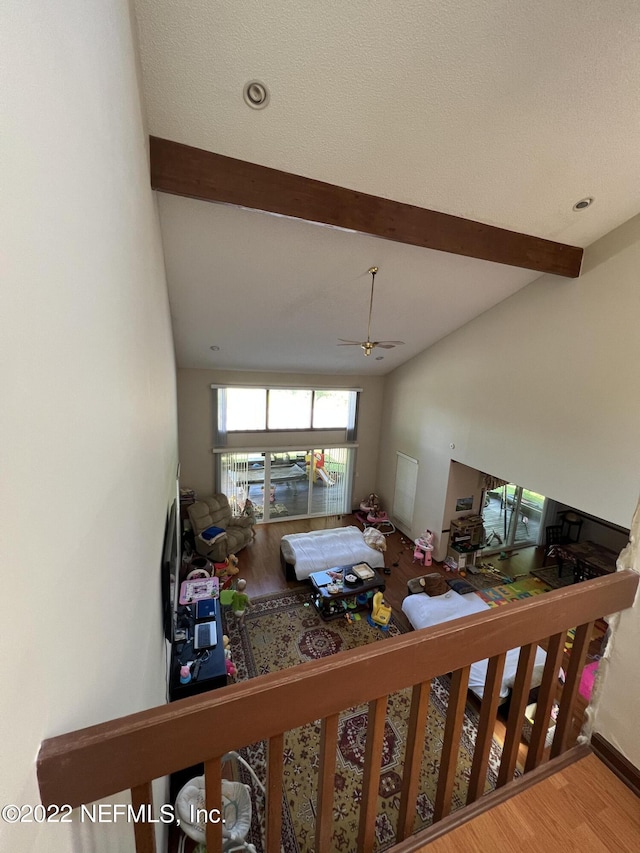 living room featuring ceiling fan, hardwood / wood-style floors, high vaulted ceiling, and a textured ceiling