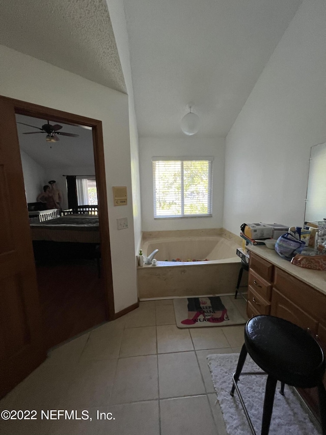 bathroom with a textured ceiling, a tub to relax in, tile patterned floors, and ceiling fan