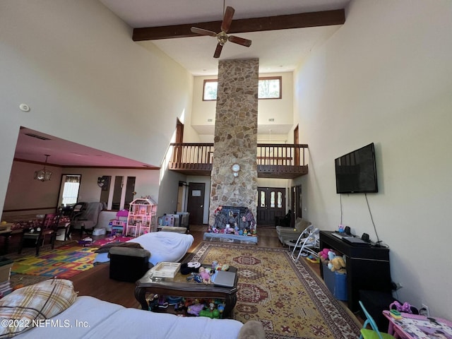 living room featuring hardwood / wood-style floors, a towering ceiling, ceiling fan, and a healthy amount of sunlight