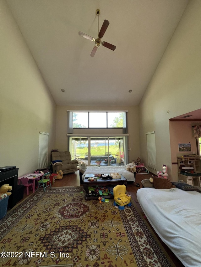 living room with ceiling fan and high vaulted ceiling