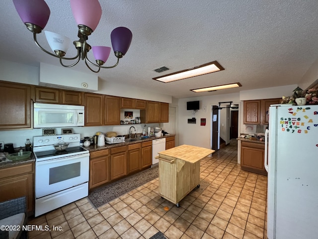 kitchen with wood counters, white appliances, an inviting chandelier, sink, and a kitchen island