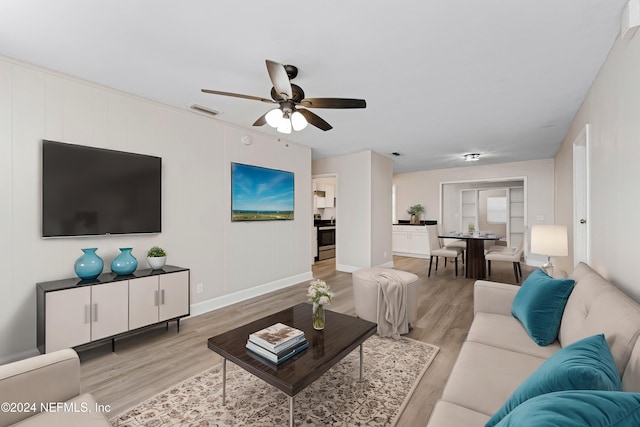 living room with ceiling fan and light hardwood / wood-style floors