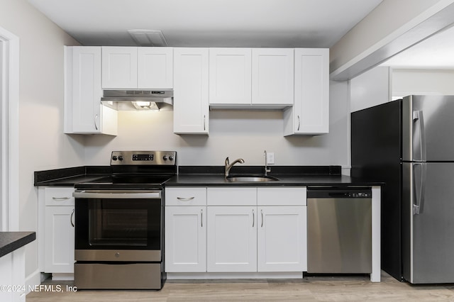 kitchen featuring white cabinets, stainless steel appliances, light hardwood / wood-style floors, and sink