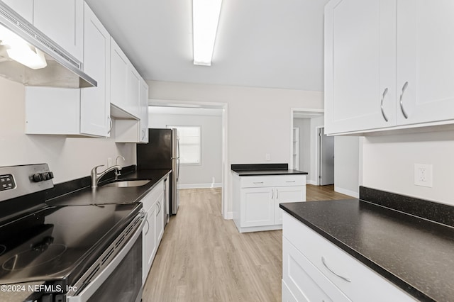 kitchen with white cabinets, stainless steel appliances, light hardwood / wood-style flooring, and dark stone countertops