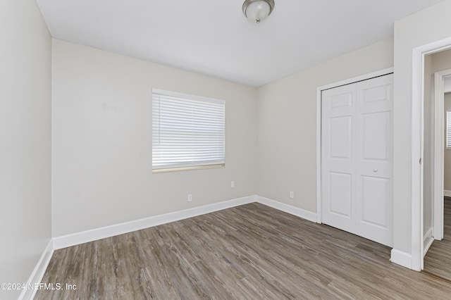 unfurnished bedroom featuring hardwood / wood-style flooring and a closet