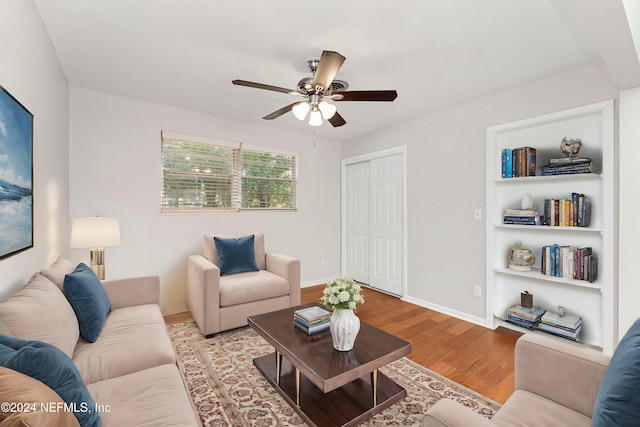 living room with ceiling fan, light hardwood / wood-style floors, and built in features