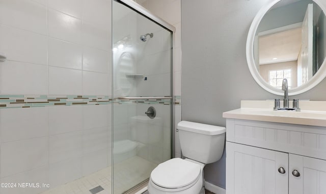 bathroom with vanity, a shower with shower door, and toilet