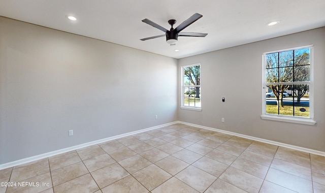 empty room with ceiling fan, a healthy amount of sunlight, and light tile patterned floors