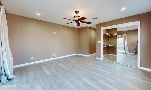 unfurnished bedroom with ceiling fan, light wood-type flooring, and a closet