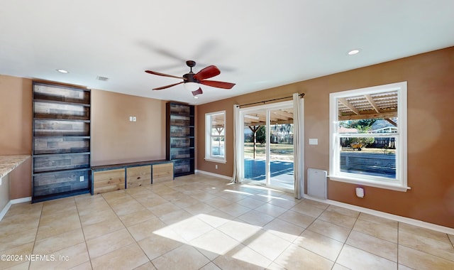 unfurnished living room with ceiling fan and light tile patterned flooring