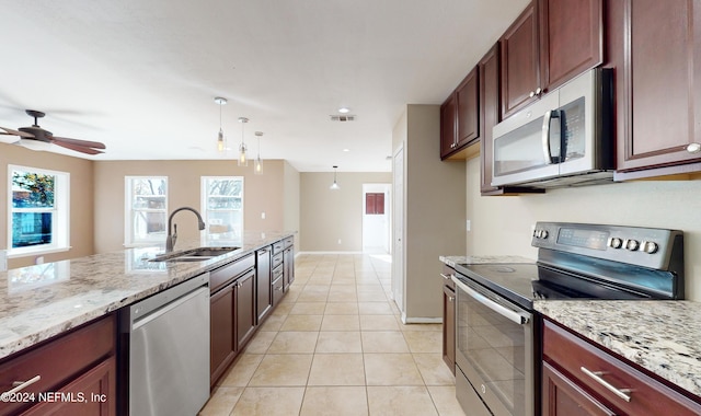 kitchen featuring hanging light fixtures, sink, ceiling fan, appliances with stainless steel finishes, and light tile patterned flooring