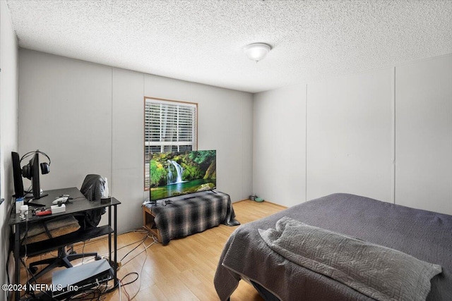 bedroom with wood-type flooring and a textured ceiling