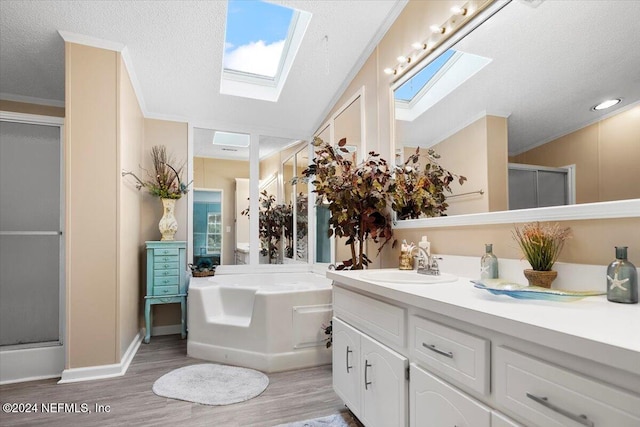 bathroom featuring vanity, wood-type flooring, crown molding, and a skylight