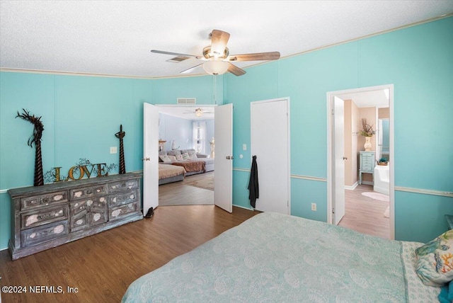 bedroom with connected bathroom, ceiling fan, crown molding, hardwood / wood-style floors, and a textured ceiling