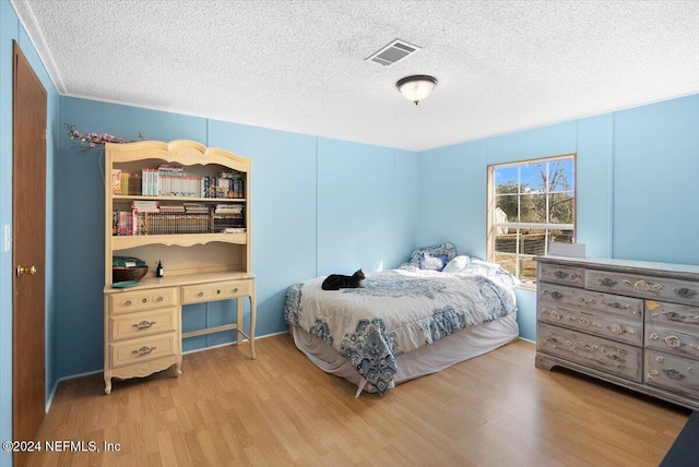 bedroom with a textured ceiling and hardwood / wood-style flooring