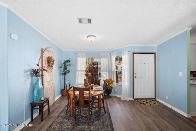 dining room featuring dark wood-type flooring, a textured ceiling, and ornamental molding