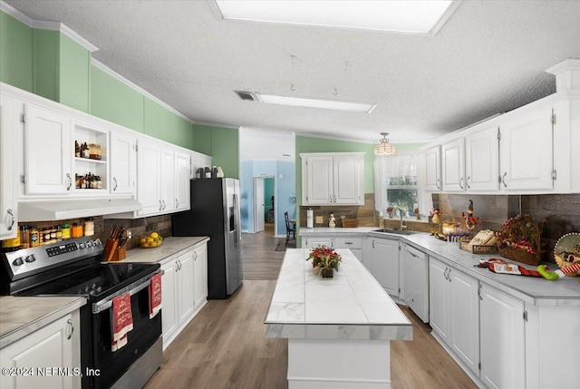 kitchen featuring decorative backsplash, light wood-type flooring, stainless steel appliances, sink, and white cabinets