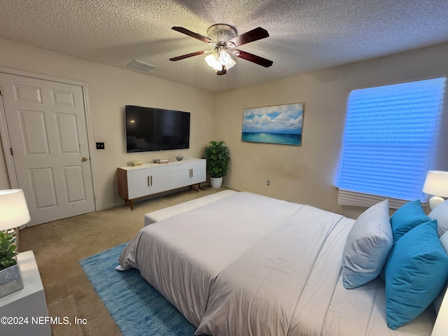 bedroom with carpet, ceiling fan, and a textured ceiling