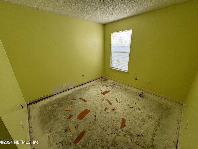 unfurnished room featuring a textured ceiling