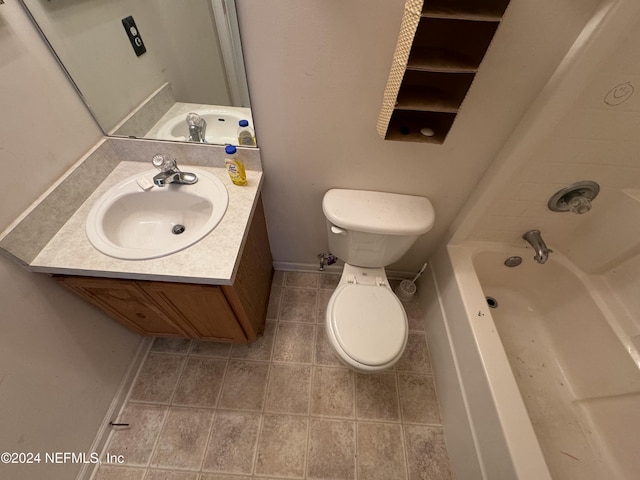 bathroom with tile patterned floors, a washtub, vanity, and toilet