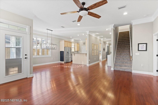 unfurnished living room featuring ceiling fan, dark hardwood / wood-style flooring, crown molding, and a textured ceiling