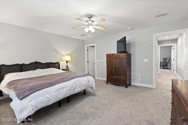 carpeted bedroom featuring ceiling fan and a textured ceiling