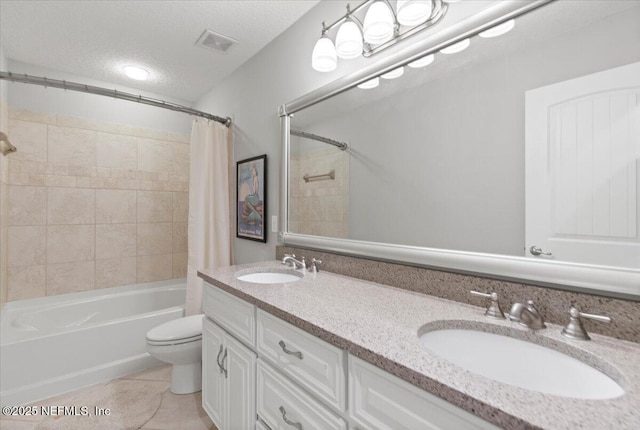 full bathroom featuring shower / bath combo, vanity, tile patterned flooring, toilet, and a textured ceiling