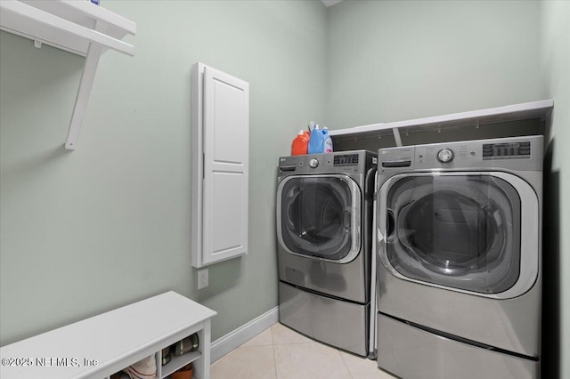 laundry area with light tile patterned floors and washing machine and clothes dryer