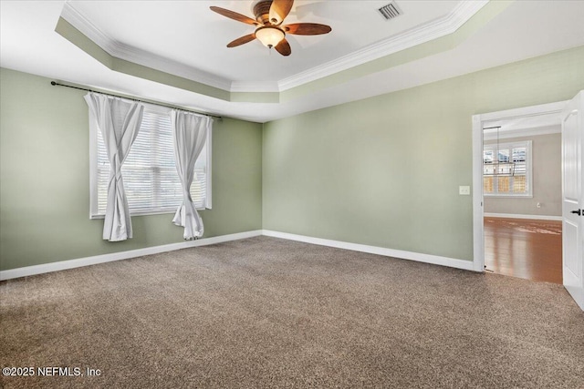 carpeted spare room with ceiling fan with notable chandelier, crown molding, and a tray ceiling